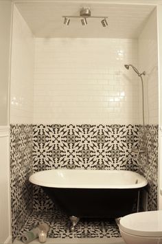 a black and white bath tub sitting next to a toilet