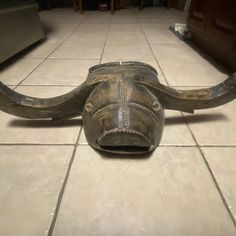 an animal's head is laying on the floor in front of a tile floor