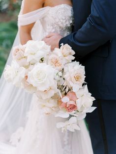 the bride and groom are holding their wedding bouquet