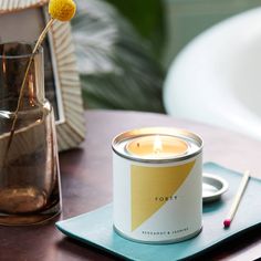 a candle sitting on top of a table next to a vase