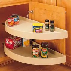 two tiered spice rack in the corner of a kitchen cabinet with spices on it