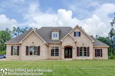 a large brick house sitting on top of a lush green field