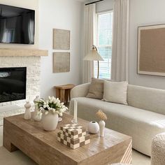 a living room filled with furniture and a flat screen tv mounted on the wall above a fireplace