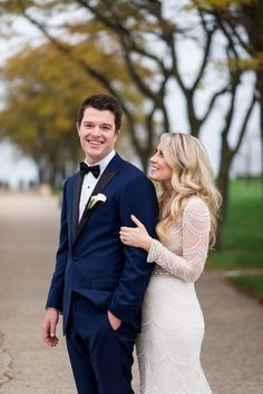 a man in a tuxedo standing next to a woman in a wedding dress