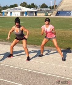 two women are doing squats on a track