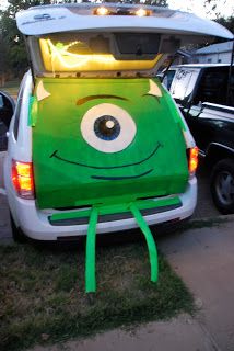 the back end of a car with an open trunk and eyes painted on it's side