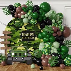 a jeep is parked in front of a jungle themed birthday party arch with balloons and greenery