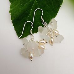 DESCRIPTION| These sea glass and fresh water pearl cluster earrings are perfect for a touch of elegance. Combining clear sea glass with white freshwater pearls for a tastefully feminine accessory that's fun to wear! While each pair is made to order and will have slight variations, the ones you receive will very closely resemble the ones pictured.  DETAILS| Approximately 1.5" total length All findings are sterling silver  All wire earrings come with rubber stoppers to keep them in place Your purc Elegant Silver Sea Glass Earrings, Elegant Sea Glass Dangle Earrings, Clear Sea, Pearl Cluster Earrings, Lover Jewelry, White Sea Glass, Glass Creations, Jewelry Beach, White Sea