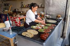 a woman preparing food on top of an outdoor grill