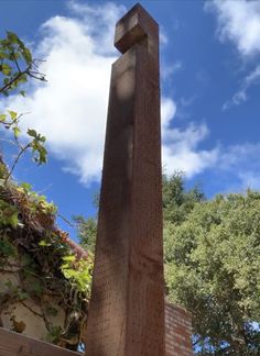 a tall wooden obelisk sitting in the middle of a park next to trees