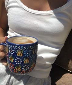 a woman holding a coffee cup in her hand