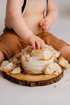 a baby sitting on top of a piece of wood with food all over it's body