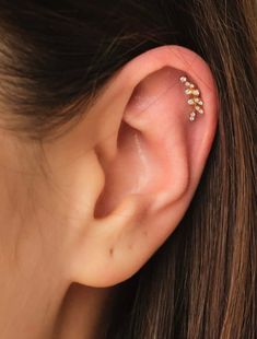 a close up of a person's ear with three small flowers on it