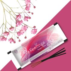 two incense sticks next to pink flowers on a pink and white background with the words greetings written in black ink