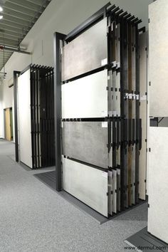 an empty room with several doors and floor tiles on the walls, in front of two rows of partitions