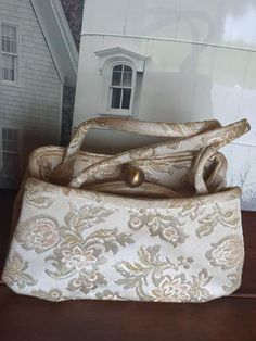 9" across the bottom, 5 1/4" tall, at highest point of purse not including handles. 2 3/4" wide across the bottom. The handles are 5" tall from the middle of the bag to the mid point of the handles. The purse is very clean well made. No damage or repairs, original condition.  Made of very pretty satiny, tapestry fabric. The colors are subtle and classic. Grey, cream, peach and greenish hue. Purse looks never used. Great piece for use and display. Formal Beige Bags With Rolled Handles, Elegant Formal Fabric Bags, Elegant Evening Fabric Shoulder Bag, Elegant Fabric Shoulder Bag, Elegant Evening Shoulder Bag In Fabric, Formal Vintage Tapestry Bag, Vintage Formal Tapestry Bag, Formal Beige Tote Evening Bag, Formal Beige Tote-style Evening Bag