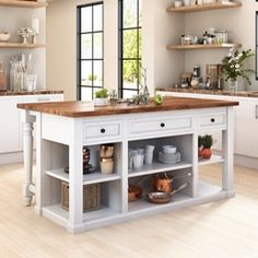 an open kitchen with white cabinets and wooden counter tops, along with lots of windows