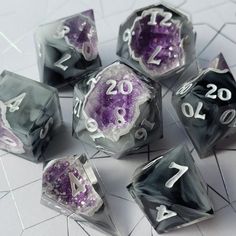 seven dice with numbers on them sitting on a tile floor in front of a white background