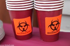 red cups with biohazard stickers on them are sitting next to each other