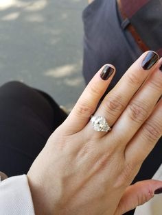 a woman's hand with a ring on it and a diamond in the middle