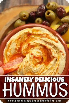 hummus in a bowl with olives and peppers