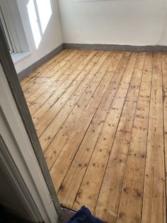 an empty room with wood floors and white walls