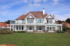 a large white house sitting on top of a lush green field