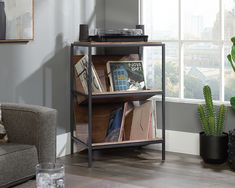 a living room with a couch, table and bookshelf next to a window