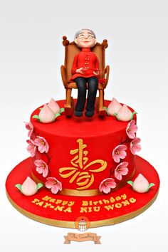 an old woman sitting in a chair on top of a red cake