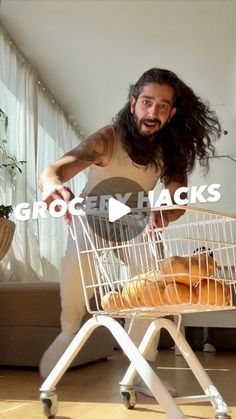 a man with long hair standing in front of a wire basket filled with donuts