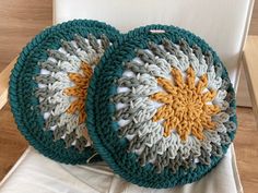 two crocheted plates sitting on top of a white chair