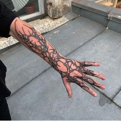 a person with a tattoo on their arm is holding his hand out to the camera