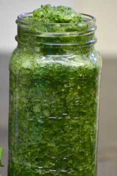 a jar filled with green liquid sitting on top of a table