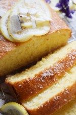 slices of lemon pound cake sitting on top of a cooling rack next to sliced lemons