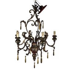 a chandelier with candles hanging from it's center and two birds on top