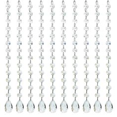 a set of seven crystal beaded necklaces hanging from hooks on a white background