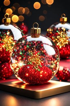 three christmas ornaments sitting on top of a wooden table with lights in the back ground