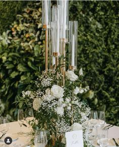 an elegant centerpiece with white flowers and greenery