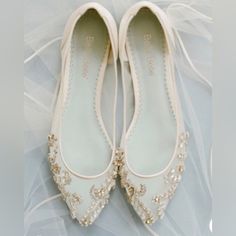 a pair of white wedding shoes with pearls on them