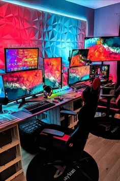 a room with multiple computer monitors and keyboards on the desk, all lit up by brightly colored lights