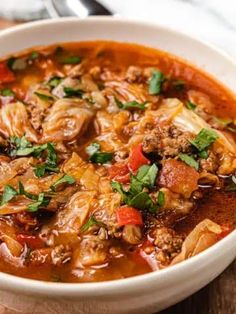 a white bowl filled with meat and vegetable soup