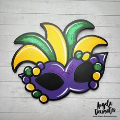 a mardi gras mask painted on the side of a wall