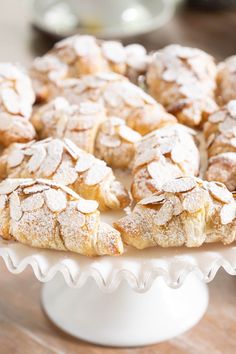 powdered sugar covered pastries sit on a cake stand, ready to be eaten