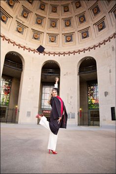 a woman standing in front of a domed building with her arms up and legs crossed