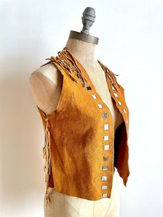 "Super rad vintage suede leather vest with square mirror appliqué details and fringe. This vest is too cool for its own good! Handmade and likely from the 70s, the vest has so much style. It has fringe lining the sides and the top seams and little mirrors that line the opening. Wear this over a dress in the summer or over a t-shirt with jeans in the Spring. Very fun piece. | Details | Modern Size: Extra Small Fabric: Suede leather Condition: Great vintage condition | Measurements | all measureme Luxury Vintage Brown Vest, Festival Fringe Brown Vest, Brown Fringe Vest For Festival, Vintage Leather Vest, 1950s Cocktail Dress, Black Pleated Dress, Suede Vest, Black Party Dresses, Vintage Vest