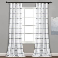 a white and blue striped curtain hanging in front of a window with two pictures on the wall