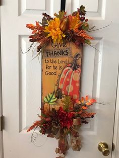 a door hanger decorated with fall leaves and pumpkins that says give thanks to the lord for he is good