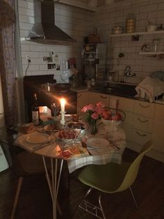 a table with food and candles on it in a kitchen next to a stove top oven