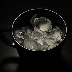 a cup filled with ice and water on top of a table