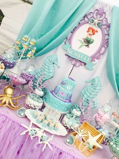 a table topped with cake and cupcakes covered in blue frosted icing